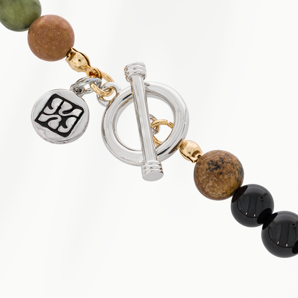 Detail van de zilverkleurige roestvrijstalen togglesluiting van de Forest Green kralenketting voor heren, met ronde bedel en goudkleurige accenten.