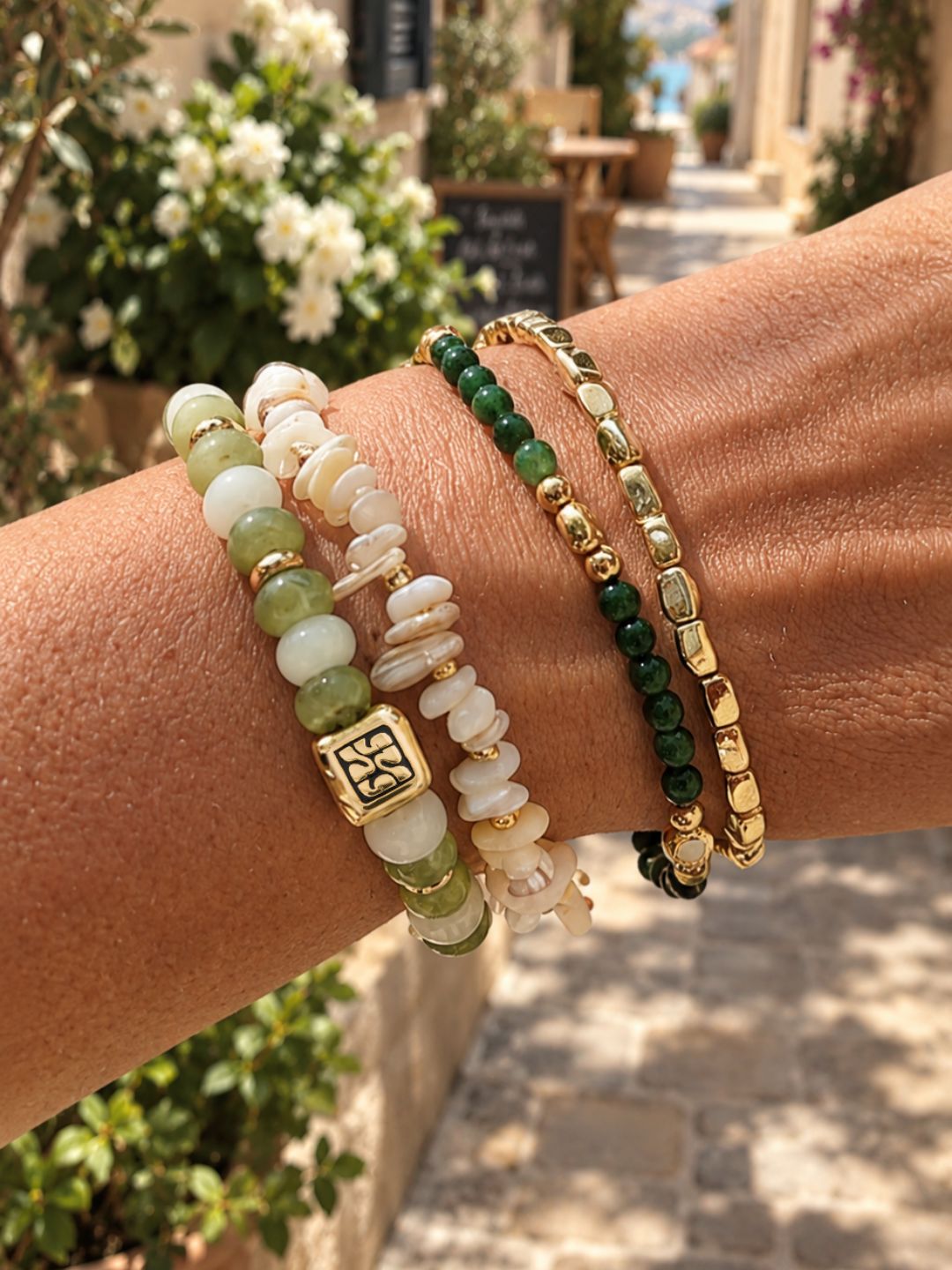 Armbandenset Jade Bloom van SummerGear met groene en witte kralen en goudkleurige details, gedragen om de pols.
