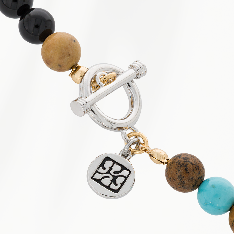 Detail van de zilverkleurige roestvrijstalen sluiting van de Ocean Blue kralenketting voor heren, met ronde SummerGear-bedel en goudkleurige accenten.