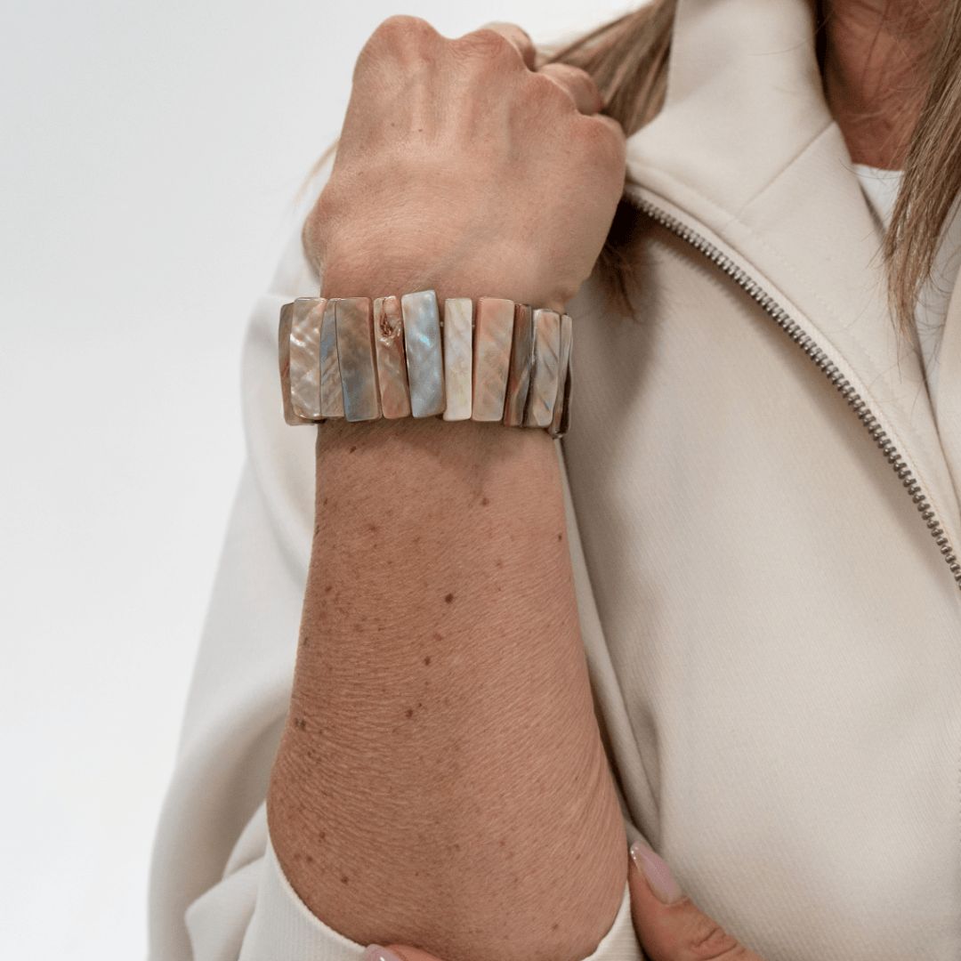 Sand Shell Slim parelmoer armband gedragen om de pols met natuurlijke zand- en schelpkleuren