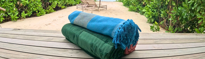 Strandlaken en hamamdoek van SummerGear op een houten vlonder bij het strand