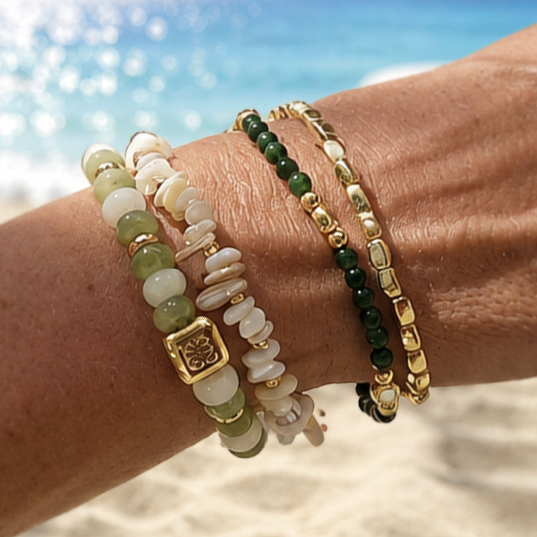 Armbandenset Jade Bloom met groene kralen en goudkleurige details gedragen op het strand
