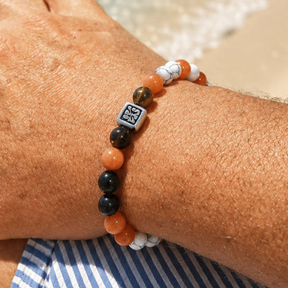 Oranje-zwarte natuursteen kralenarmband voor heren om een mannenpols op het strand.
