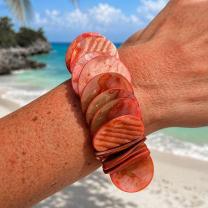 Parelmoer armband Luna Clay met ronde roze en roodbruine schakels gedragen op het strand