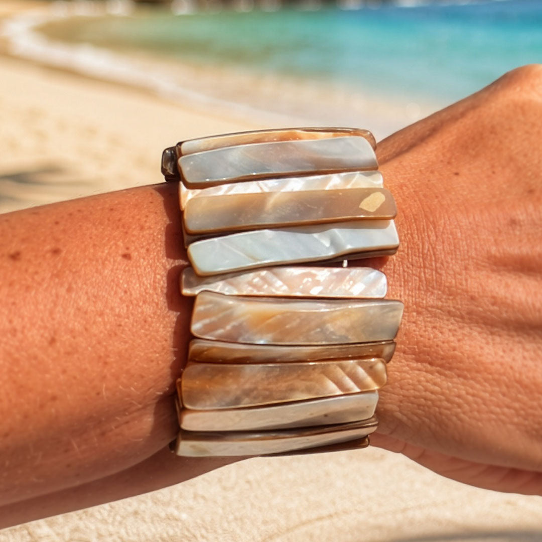 Parelmoer armband Sand Shell met langwerpige beige en parelmoerkleurige schakels gedragen op het strand