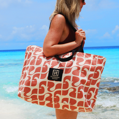 Roze SummerGear Amora strandtas gedragen op het strand met ruime inhoud voor een dag buiten