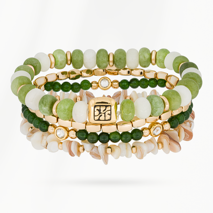 Jade Bloom armbandenset van SummerGear met vier armbanden van groene en witte kralen, schelpdetails en goudkleurige accenten.