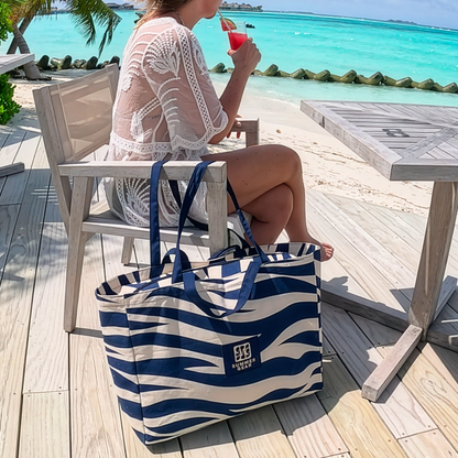 Canvas strandtas op terras bij zee met strandlaken erin, ruime beach bag voor strand en dagelijks gebruik