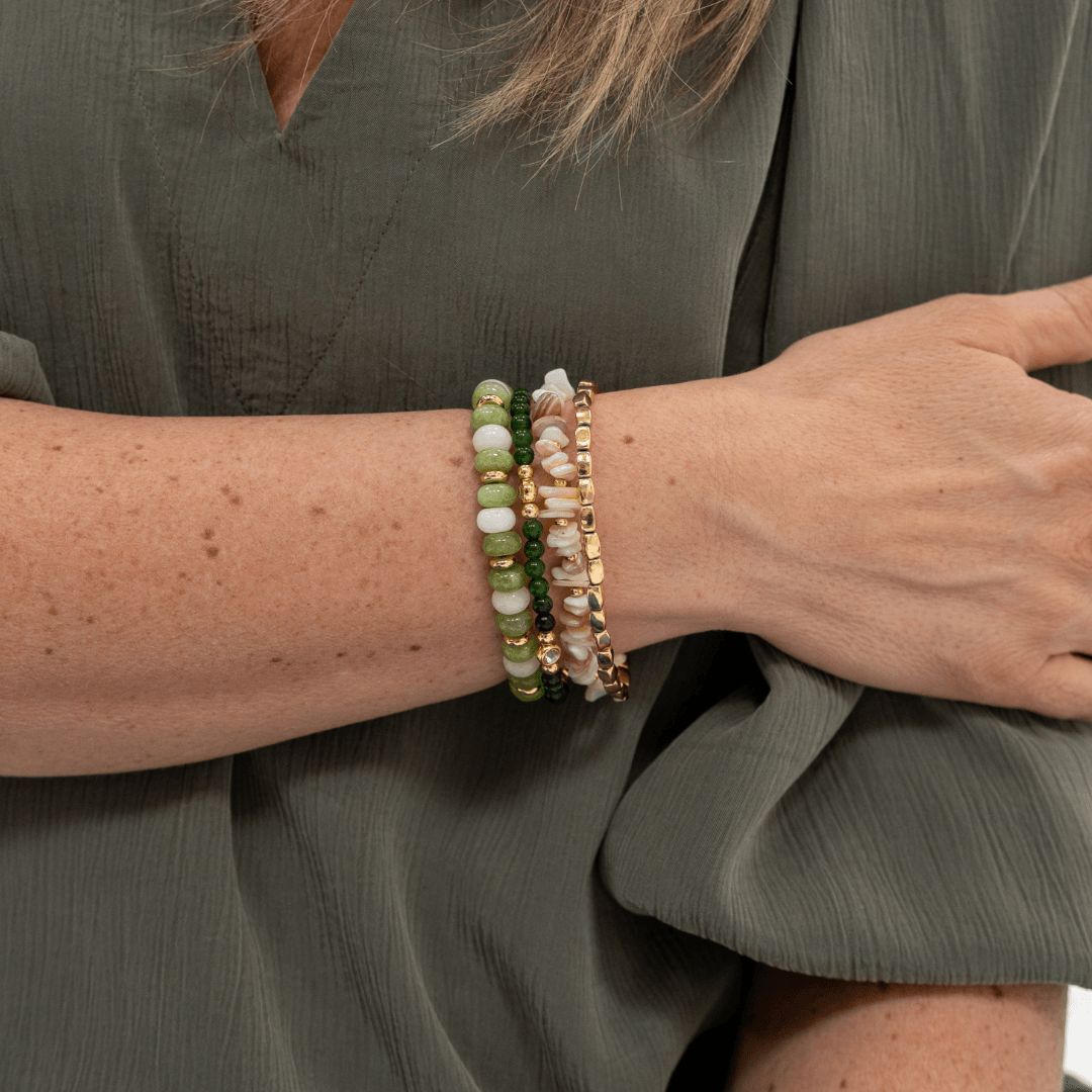 Natuursteen armband Jade Bloom met groene natuursteen kralen en vergulde details gedragen om de pols