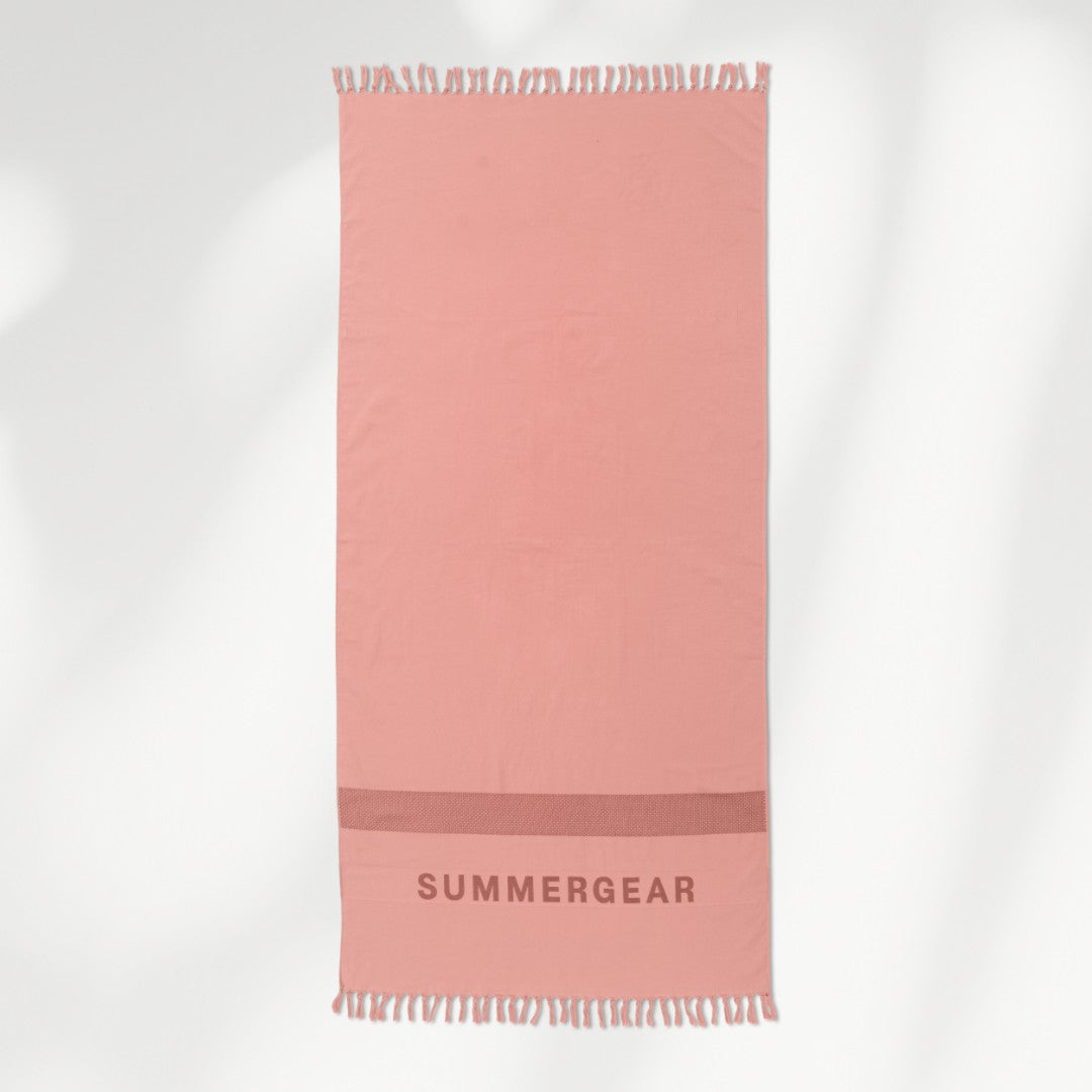 Roze lichtgewicht strandlaken volledig uitgerold in studio