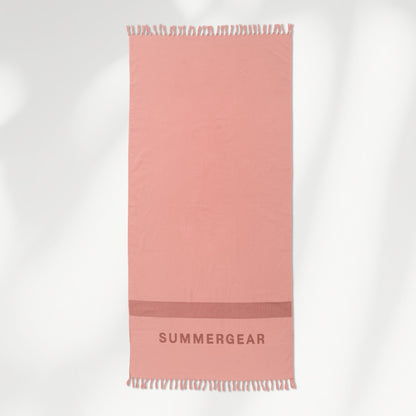 Roze lichtgewicht strandlaken volledig uitgerold in studio