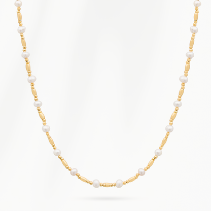 Ripple Chain parelketting van SummerGear met kleine witte parels, langwerpige goudvergulde schakels en fijne goudkleurige kralen op een witte achtergrond.