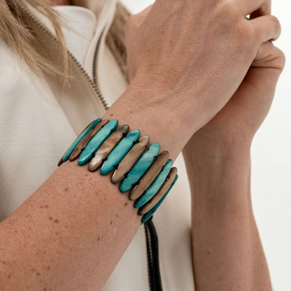 Elastische schelp armband Dune Lagoon met blauwgroene parelmoer delen gedragen om de pols