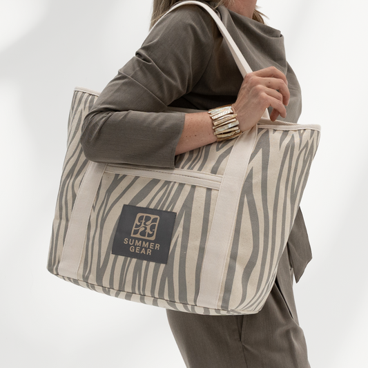 Strandtas met rits Avalon middelgroot die volledig afsuit met rits van  canvas in de kleur naturel en grijs gedragen door model