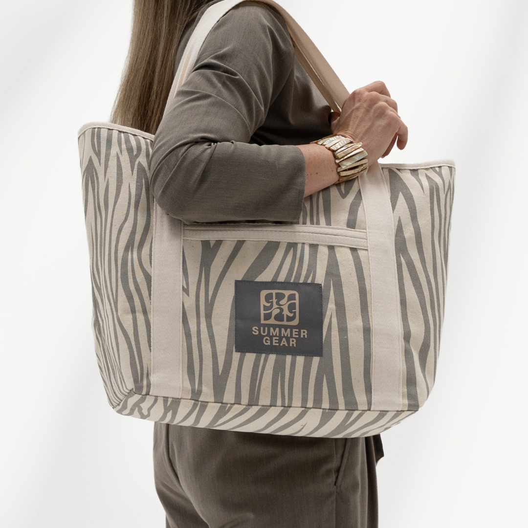 Strandtas met rits Avalon middelgroot die volledig afsuit met rits van  canvas in de kleur naturel en grijs gedragen door model