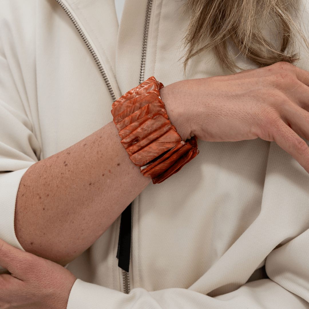 Roodbruine statement parelmoer armband Amber Shell gedragen aan de arm