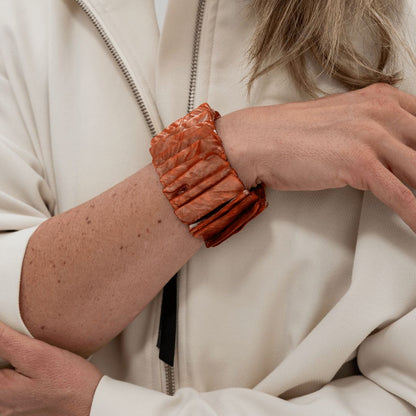 Roodbruine statement parelmoer armband Amber Shell gedragen aan de arm