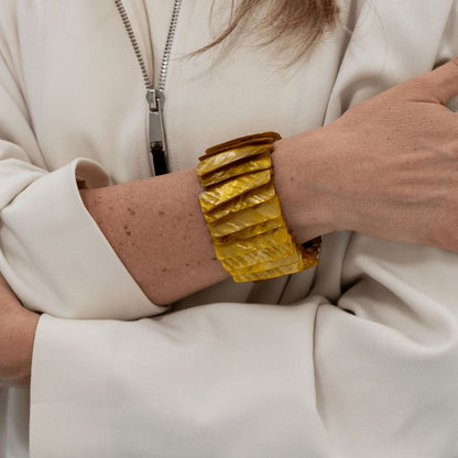 Brede goudbruine parelmoer armband Honey Shell gedragen om de pols