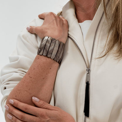 Brede parelmoer armband Stone met koele grijsbruine tinten gedragen om de pols