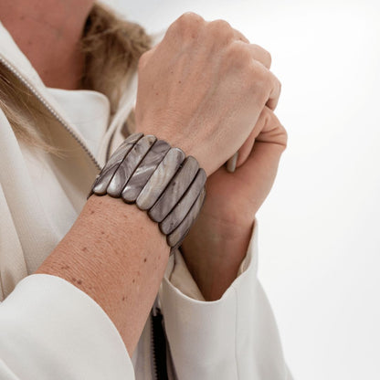 Brede Stone parelmoer armband met natuurlijke grijze glans om de pols