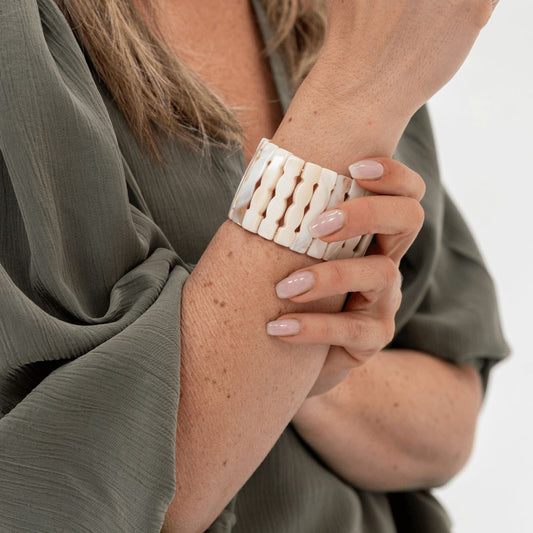 Brede parelmoer armband Wave met witte natuurlijke glans gedragen om de pols